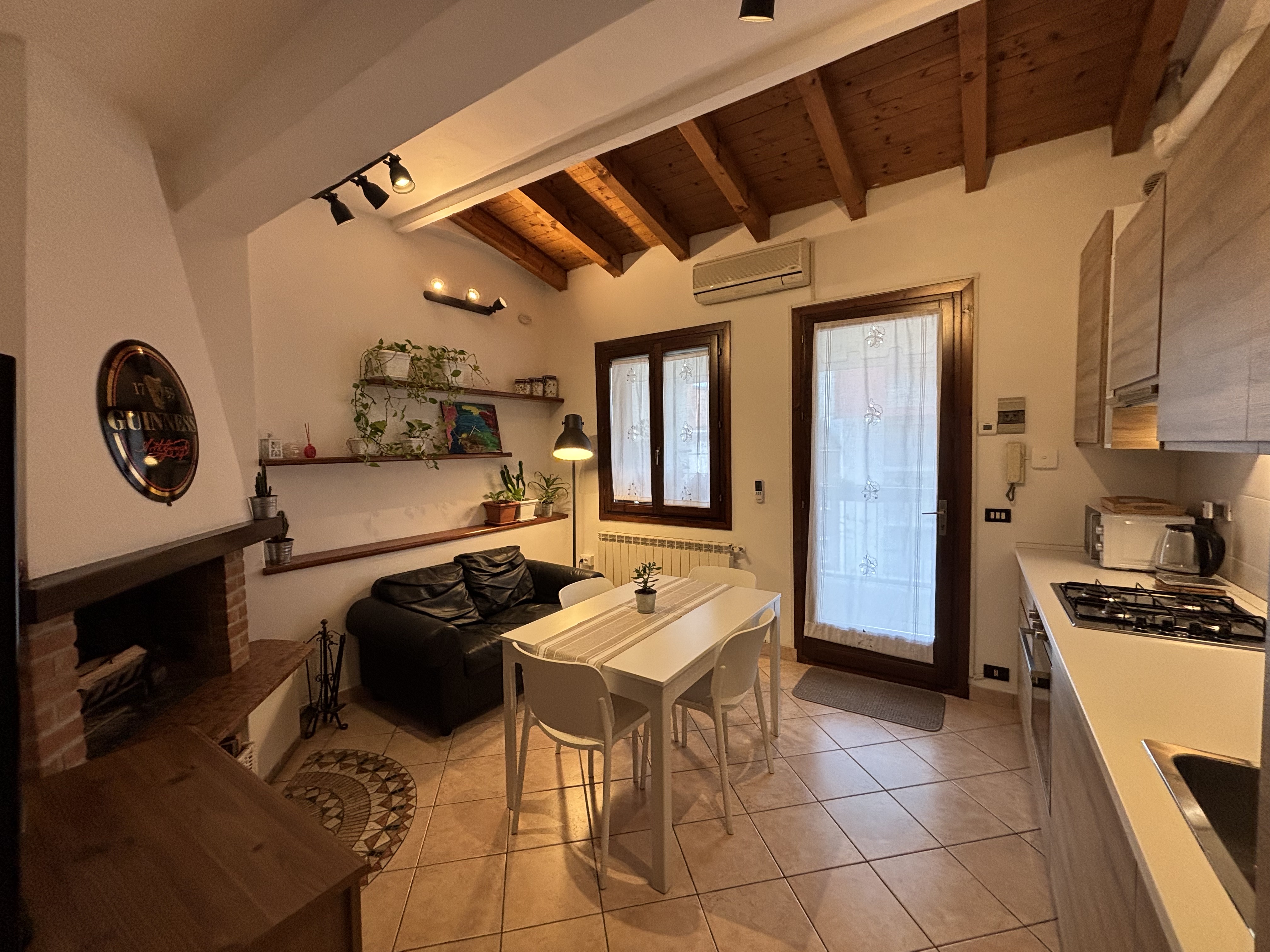 Soggiorno con camino e porta-finestra sul balcone